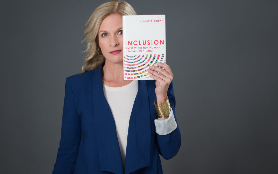 Jennifer Brown holding up her book, Inclusion
